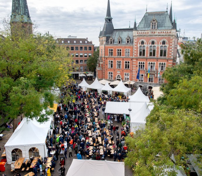 Auf dem Oldenburger Rathausmarkt sind zu hallo Grünkohl viele Stände und lange Sitzreihen zum Essen aufgebaut.